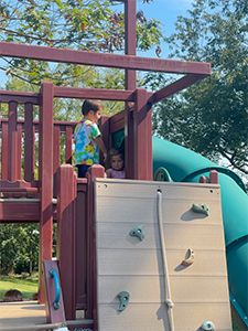 2 children playing together on the palyground at Stepping Stones Child Care