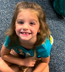 A young girl smiling at Stepping Stones Child Care