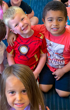 Children sitting together, waiting for an activity to begin at Stepping Stones Child Care